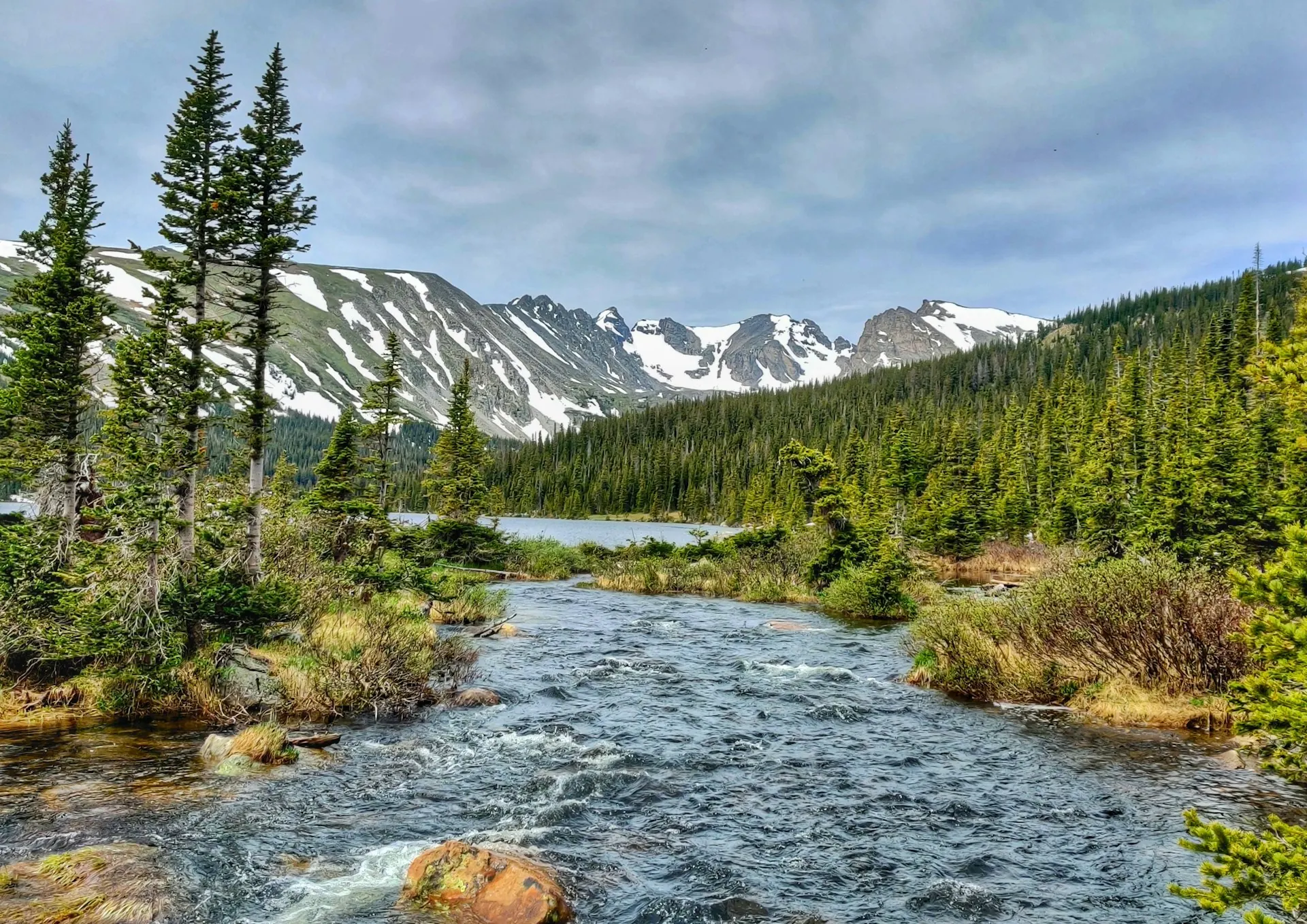 Mountain river beneath snowy Colorado peaks